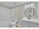 Bathroom showing a new tub, toilet, vanity with a round mirror and modern vanity lights at 2080 Saint Paul Church Rd, Roxboro, NC 27574