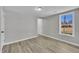 A bedroom boasts gray walls, wood floors, a large window with a yard view, and one entry door at 2080 Saint Paul Church Rd, Roxboro, NC 27574
