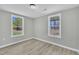 The bedroom features neutral gray walls, wood floors, and two windows overlooking a green yard at 2080 Saint Paul Church Rd, Roxboro, NC 27574