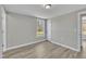 A bedroom shows wood floors, gray walls, a window, and an entry door with glass at 2080 Saint Paul Church Rd, Roxboro, NC 27574