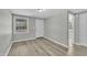 A bright bedroom features gray walls, new light wood floors, a window and exterior door at 2080 Saint Paul Church Rd, Roxboro, NC 27574