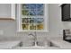 Close-up of a stainless kitchen sink and faucet under a bright window view at 2080 Saint Paul Church Rd, Roxboro, NC 27574