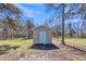 A cozy outbuilding with a blue door sits amongst the trees on a clear day at 2080 Saint Paul Church Rd, Roxboro, NC 27574