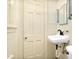 Bathroom features a modern black faucet, white sink, and a door on white tile at 2120 Cokey Rd, Rocky Mount, NC 27801