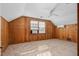 Bedroom featuring wood paneled walls, neutral carpet, a ceiling fan, and a window with blinds for natural light at 2120 Cokey Rd, Rocky Mount, NC 27801