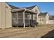View of tan two-story home featuring a screened porch with black railing and steps at 2120 Cokey Rd, Rocky Mount, NC 27801