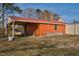 View of backyard shed, open on one side, with a red roof and orange siding at 2120 Cokey Rd, Rocky Mount, NC 27801