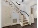 Elegant staircase with white railings and dark wood treads, complemented by an adjacent doorway and dark wood floors at 2120 Cokey Rd, Rocky Mount, NC 27801