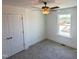 A carpeted bedroom has a ceiling fan, closet and window to provide natural light and closet space at 22 Twin Birch Dr, Angier, NC 27501