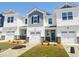 View of new townhomes with garages, landscaping, and grass, in a suburban setting on a sunny day at 22 Twin Birch Dr, Angier, NC 27501