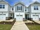 Charming townhouse featuring a white exterior, gray accents, well-kept lawn, and attached one car garage at 22 Twin Birch Dr, Angier, NC 27501