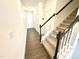 Hallway with hardwood floors, white walls, a staircase, and natural light filtering in at 22 Twin Birch Dr, Angier, NC 27501