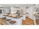 Bright, modern kitchen features white cabinetry, stainless steel appliances, and a spacious island with seating at 243 Augusta Pond Way # 163, Raleigh, NC 27603