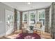 Bright sunroom with hardwood floors, stylish decor, and views of the outdoors from three large windows at 243 Augusta Pond Way # 163, Raleigh, NC 27603