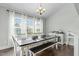 Elegant dining room with ample natural light and a modern chandelier above the table at 2801 Landon Ridge Dr, New Hill, NC 27562