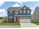 Charming two-story home with blue siding, a red front door, and a white two-car garage at 2801 Landon Ridge Dr, New Hill, NC 27562