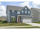 Charming two-story home with blue siding, a red front door, and a white two-car garage at 2801 Landon Ridge Dr, New Hill, NC 27562