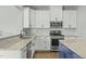 Close up of the kitchen with white cabinets, granite counters and stainless appliances at 2801 Landon Ridge Dr, New Hill, NC 27562