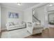 Cozy living room with hardwood floors, neutral furniture, and a staircase in the background at 2801 Landon Ridge Dr, New Hill, NC 27562