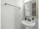 Cozy powder room featuring a stylish pedestal sink, mirror and modern fixtures at 2801 Landon Ridge Dr, New Hill, NC 27562
