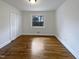 Cozy bedroom with hardwood floors, white walls, a window with view, and a double door closet at 300 Perry St, Rolesville, NC 27571