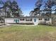 Charming white brick ranch-style home with a vibrant blue front door and meticulously manicured front lawn at 300 Perry St, Rolesville, NC 27571