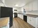 Well-lit kitchen featuring white cabinetry, a black refrigerator, and modern fixtures at 300 Perry St, Rolesville, NC 27571