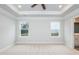 Bright primary bedroom features a tray ceiling, ceiling fan, and two windows for natural light at 316 Hopewell Branch Ct, Smithfield, NC 27577