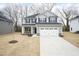 Two-story home with gray siding, black shutters, and a two-car garage on a lawn with dormant grass at 316 Hopewell Branch Ct, Smithfield, NC 27577