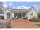 Beautiful back porch with brick patio, covered seating area, and manicured lawn at 321 Nottingham Dr, Chapel Hill, NC 27517