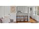 Inviting bar area with white cabinets, marble counter, and seating for three at 321 Nottingham Dr, Chapel Hill, NC 27517