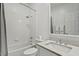 Clean and well-lit bathroom with white tile, tub shower, and marble countertop vanity at 321 Nottingham Dr, Chapel Hill, NC 27517