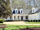 Charming home featuring a manicured lawn, two-car garage, and inviting front porch with rocking chairs at 321 Nottingham Dr, Chapel Hill, NC 27517