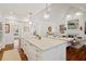 Bright, open kitchen with a large island, modern lighting, and stainless steel appliances seamlessly transitions to the living room at 321 Nottingham Dr, Chapel Hill, NC 27517
