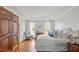 Main bedroom featuring white walls, tray ceilings, hardwood floors, and an armoire at 321 Nottingham Dr, Chapel Hill, NC 27517