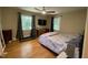 Bright bedroom featuring hardwood floors, two windows, ceiling fan, and a full-size bed at 321 Willowood Dr, Henderson, NC 27536