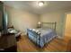 Bright bedroom with hardwood floors, a chair, 2 windows and a bed with black iron frame at 321 Willowood Dr, Henderson, NC 27536