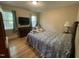 Bedroom with hardwood floors, 2 windows and blue curtains with an accent chair and a bed at 321 Willowood Dr, Henderson, NC 27536