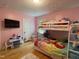 Bright pink bedroom featuring a bunk bed, tv, and small desk at 321 Willowood Dr, Henderson, NC 27536