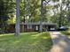 Charming brick home with mature trees, a covered carport, and a long driveway at 321 Willowood Dr, Henderson, NC 27536