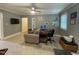 This living room features a tile floor, ceiling fan, computer desk and wall-mounted TV at 321 Willowood Dr, Henderson, NC 27536