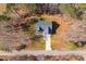 Aerial view of a home nestled in a wooded area featuring a long driveway and well-maintained landscaping at 35 Wickersham Way, Louisburg, NC 27549