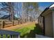 Large backyard with a mix of grass and bare ground, featuring a wooden privacy fence at 35 Wickersham Way, Louisburg, NC 27549