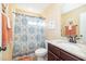 Cozy bathroom featuring a stylish vanity, toilet, and shower with decorative curtains, offering a functional and inviting space at 35 Wickersham Way, Louisburg, NC 27549