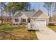 Well-kept single-story home with an attached garage, accessible ramp, manicured landscaping, and a welcoming facade at 35 Wickersham Way, Louisburg, NC 27549