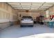 Spacious two-car garage with painted walls, concrete flooring, and a door to the main house at 35 Wickersham Way, Louisburg, NC 27549