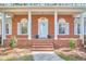 Charming brick home featuring covered front porch with columns, manicured landscaping, and inviting entrance at 3613 Hope Valley Rd, Durham, NC 27707