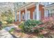 Brick home featuring an inviting entrance, white columns, shutters, and lush landscaping at 3613 Hope Valley Rd, Durham, NC 27707
