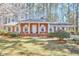 Charming red brick home with white shutters, portico and blossoming tree in landscaped front yard at 3613 Hope Valley Rd, Durham, NC 27707