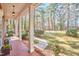 Covered front porch adorned with columns offers views of the manicured lawn, walkway and flowering tree at 3613 Hope Valley Rd, Durham, NC 27707
